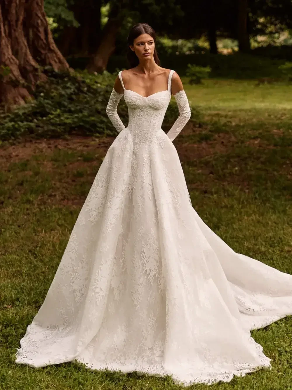 model is wearing an off the shoulder lace bridal gown