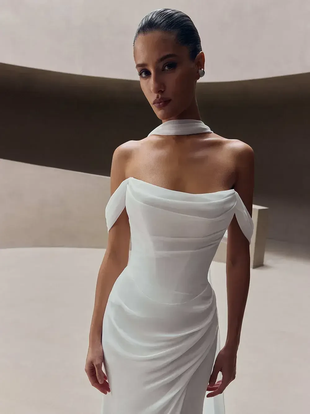 model is wearing an off the shoulder minimalist bridal gown