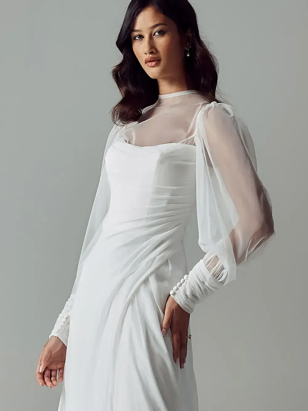 model is wearing a long sleeve bridal gown