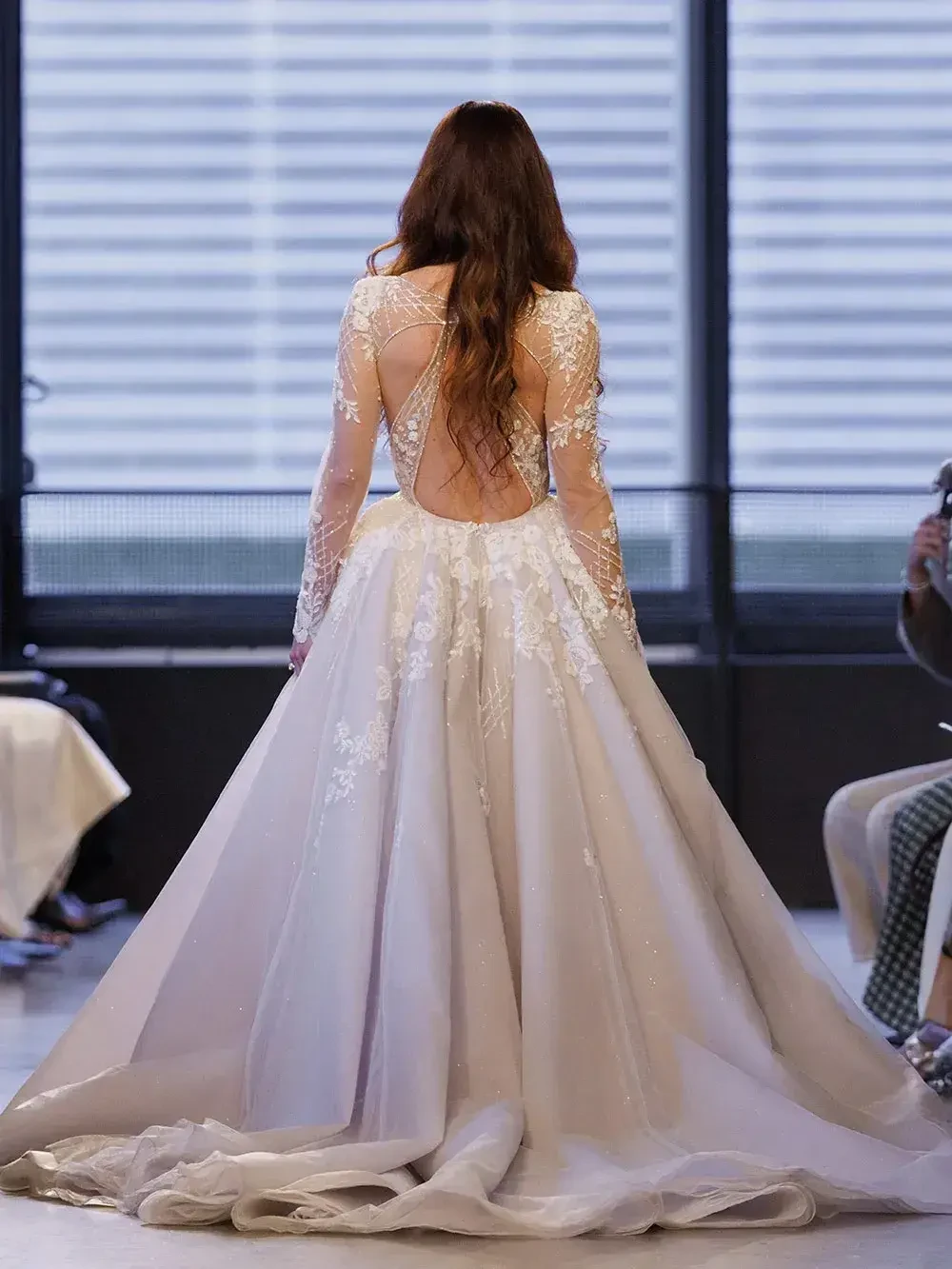 model is wearing a long sleeve bridal gown with a plunging neckline