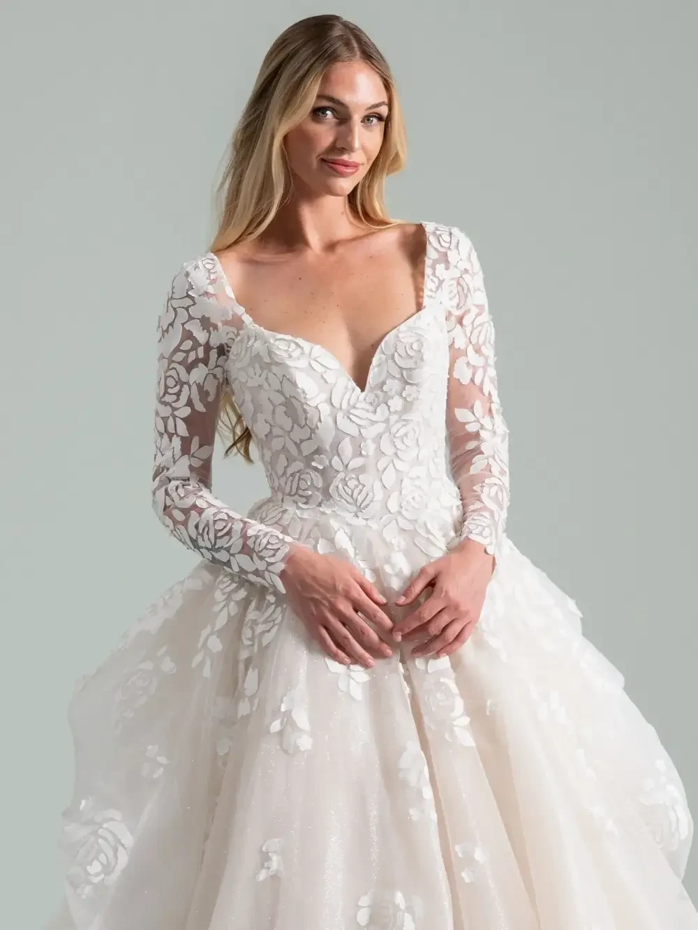 model is wearing a lace long sleeve bridal gown
