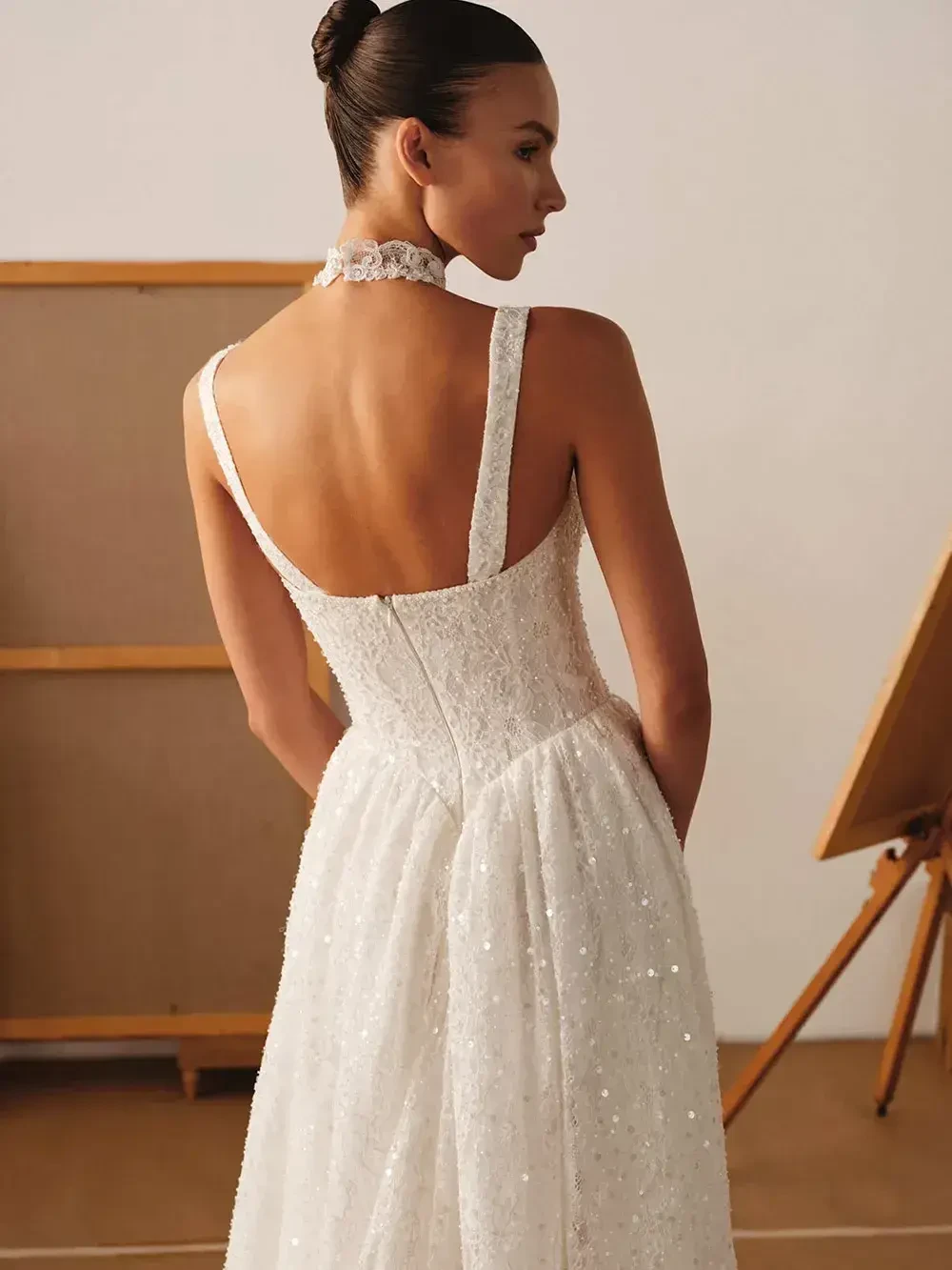 model is wearing an open back sleeveless bridal gown